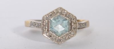 A hallmarked 9ct diamond and blue stone ring set with a pale blue central stone surrounded by