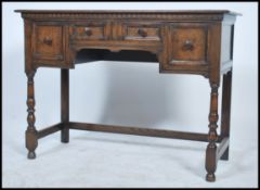 A 20th century Jacobean revival writing table - side table desk being raised on cup and cover legs