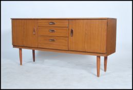 A retro 20th century teak wood effect sideboard having central bank of three drawers flanked by