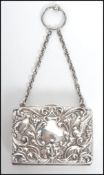 An early 20th century Edwardian ladies purse decorated with scrolls and birds having a carry chain