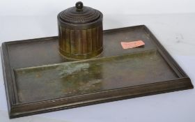 An early 20th century bronze inkwell desk tidy stand having a faceted inkwell with gadrooned lid