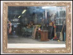 A good quality 20th century gilt wood mirror having rococo worked details with back panel and