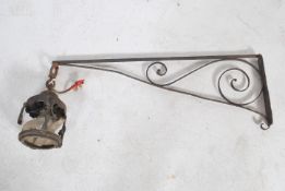 An early 20th century Arts & Crafts cast and wrought metal porch lantern set to a scroll worked