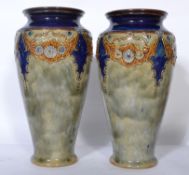 A pair of Royal Doulton early 20th century tube lined vases having tapering bodies with wasted necks
