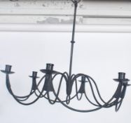 A fantastic 20th century six point wrought iron ebonised chandelier, having swag and scroll work