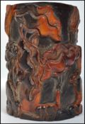 An unusual Oriental carved brush pot constructed from reconstituted tortoise shell depicting