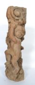 A hand carved wooden column of large form having a highly detailed putti holding the top of the