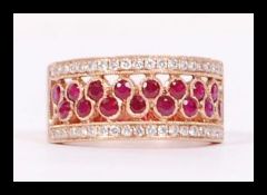 An 18ct rose gold ruby and diamond eternity ring two alternating strands of ruby's with a