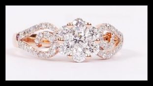 An 18ct rose gold diamond ring having a diamond cluster with pierced and scrolled shoulders,