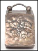 An unusual silver 925 marked miniature coal scuttle pill box with winged cherub putti to the