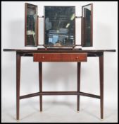 A good 1950's post modernist teak wood duchess dressing table being raised on tapering legs united