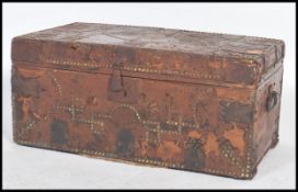 An early 19th century Georgian leather covered wooden trunk with brass studded decoration with label