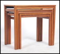 A 20th century retro teak wood nest of graduating occasional tables, each table raised on square