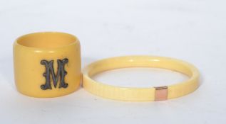A 19th century ivory bangle with a gilt metal gold band together with an ivory napkin ring.