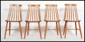 A set of 4 retro 20th century Ercol style stick back dining chairs with saddle seats raised on