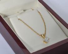 A hallmarked 18ct gold and diamond pendant necklace being strung with a four prong set princess