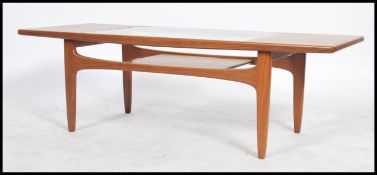 A 1970's teak G Plan teak wood atomic coffee table. The shaped legs under circular top with inset