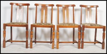 A set of four 20th century oak Art Deco dining chairs with shaped splat back raise on turned legs