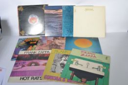 A collection of vinyl long play LP record albums containing Frank Zappa and Santana to include