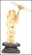 A 19th century Japanese Okimono ivory figurine of an elderly lady clutching a bag and umbrella