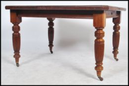 A Victorian extending pull out dining table together with an additional leaf. The table being raised