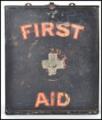 A vintage early half of the 20th century tin wall hanging First aid box, black ground with applied