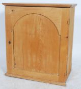 An early 20th country pine wall cupboard having panel door with multiple sectioned interior set