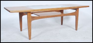 A 1970's retro G-Plan teak wood coffee table of rectaugular form raised on tapering legs with