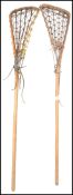 A pair of vintage 20th century Lacrosse sticks of wooden construction with nest tops. Measures: