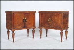 A pair of early 20th century Italian walnut bedside cabinets, each being raised on turned and