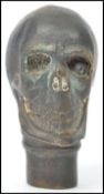 A vintage 20th century novelty gothic walking stick cane top in the form of a skull of bronze /