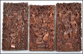 A collection of 3 20th century Indonesian / Thai hardwood carved panels in relief having scenes of