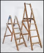 A non patching pair of vintage wooden step ladders, one with an Ivorine plaque reading Slingsbury
