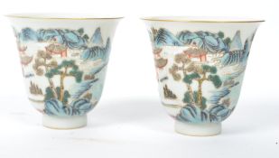 A pair of 19th century Oriental Chinese ceramic tea cups of bell form painted with a landscape scene