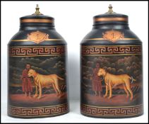 A pair of large decorative tea tins converted to lamp bases with painted decoration of man and dog