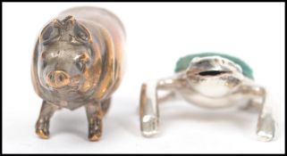 A silver novelty pin cushion in the form of a frog with green baize cushion atop along with a
