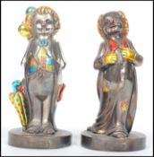 A pair of silver 925 clown figurines, each raised on plinth bases with coloured detailing. Stamped