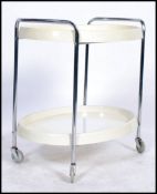 A 1970's retro chrome and plastic trolley being raised on tubular chrome supports with original