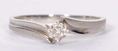 A hallmarked 18ct white gold and diamond solitaire ring having a single diamond in a prong crossover