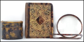 A group of tortoise shell wares to include an aid de memoir with gilt detailing, a hair clip and