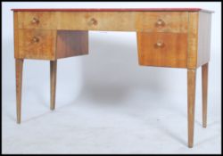 An original Gordon Russell walnut desk with an arrangement of  five drawers. All raised on tapered