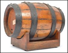 An early 20th century wooden and brass bound Coppered barrel having prunted brass bands raised on