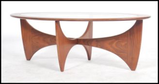 A retro teak wood atomic 'Astro' oval coffee table by G Plan, having a drop centre glass panel,
