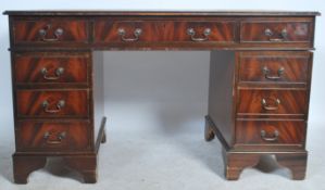 An antique style mahogany twin pedestal leather top desk being raised on plinths to each