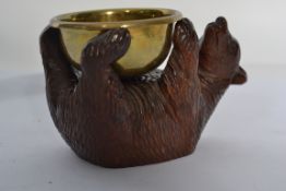 An early 20th carved oak blackforest / black forest bear carved in a reclined position with glass