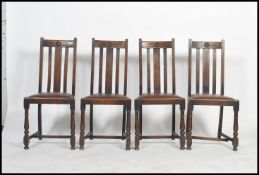 A set of 4 1930's Art Deco oak dining chairs raised on cup and cover legs united by stretchers