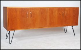 A vintage 20th century retro teak wood G-Plan sideboard dresser being raised on hairpin metal legs