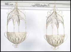 A pair of vintage 20th century cast metal hanging planters having pierced and scrolled baskets