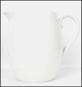 An early 20th century ceramic farmhouse cream milk dairy jug having a white glaze with banded
