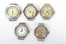 A collection of 5 silver early 20th century wrist watch movements and cases. To include silvered